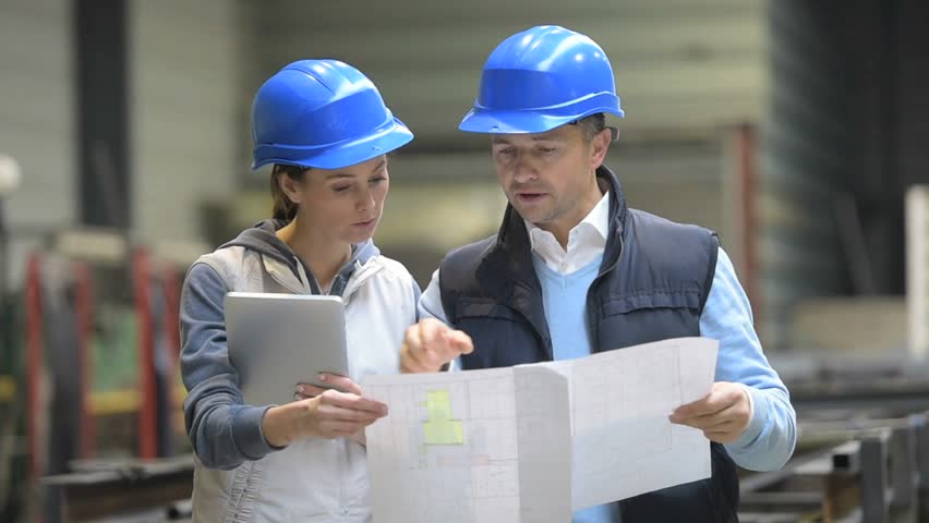 two-people-reviewing-plans-in-factory